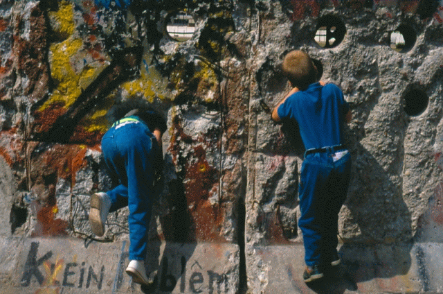 climbing through holes Berlin wall